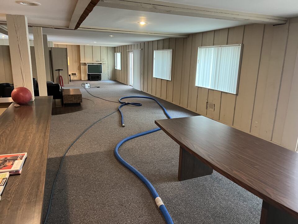 Cleaning hoses across a carpeted multipurpose room