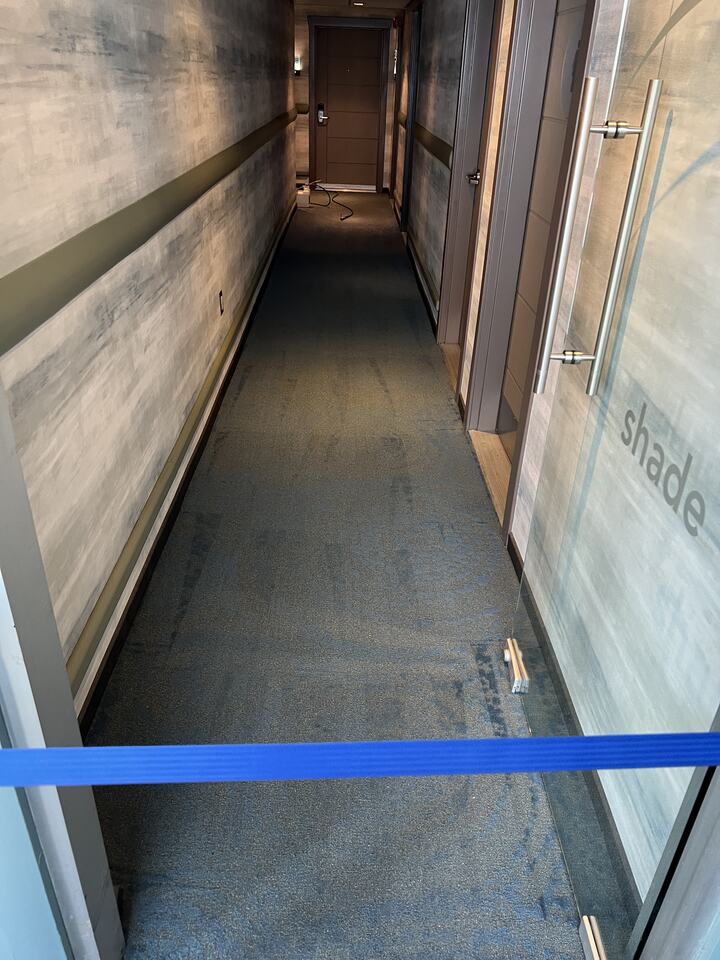 A narrow carpeted corridor in a commercial setting