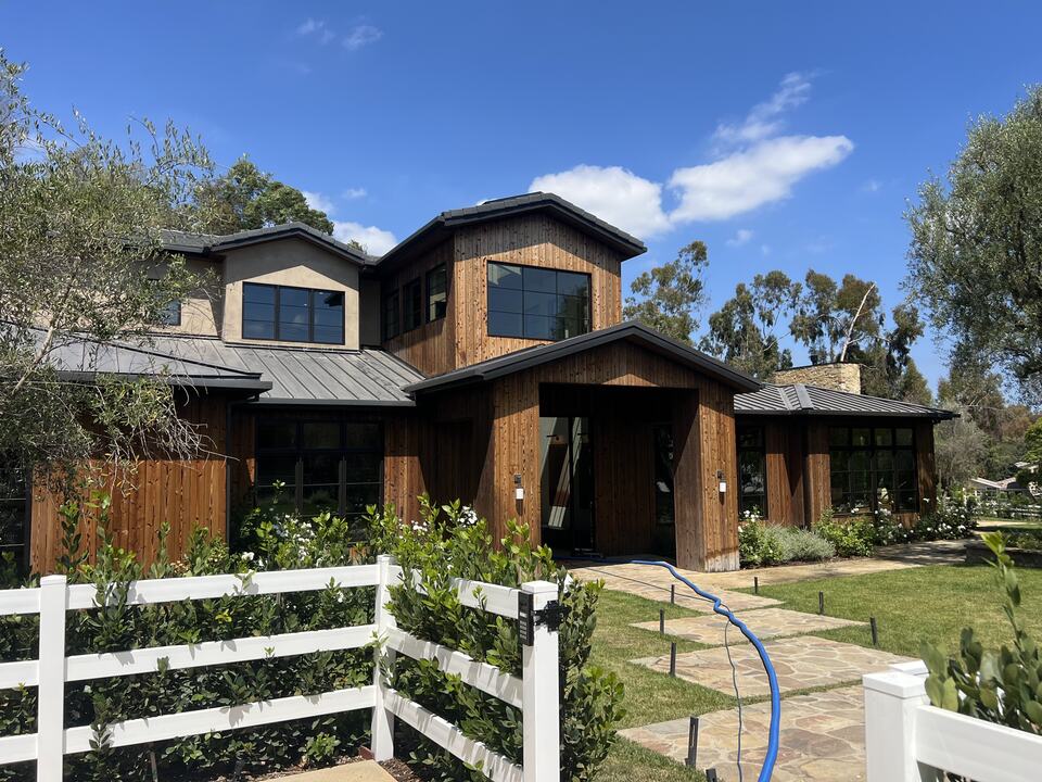House exterior with cleaning hoses leading toward the entrance