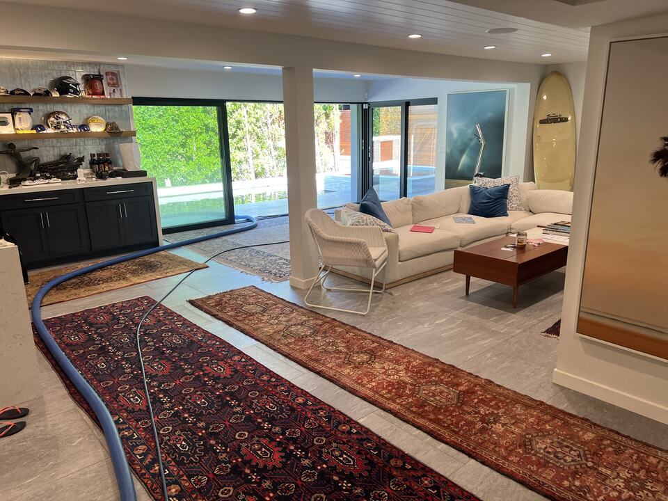 Patterned area rugs and upholstered seating in an open living room