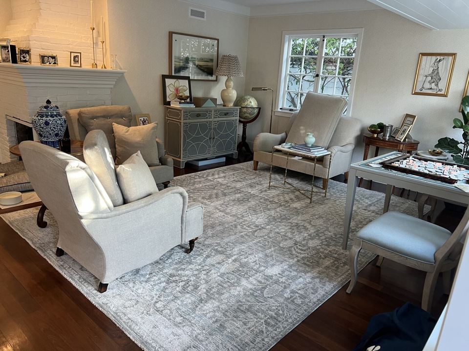Patterned area rug and upholstered seating in a furnished living room